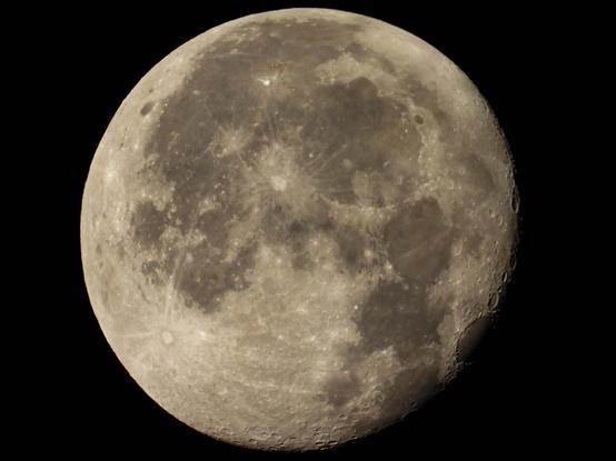 A zoomed in photo of the near full moon clearly showing the craters