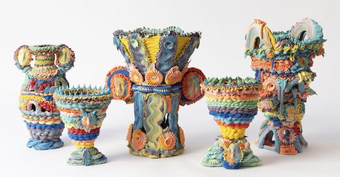 a series of five elaborate, multi-colored ceramic vases made with clay piped like frosting
