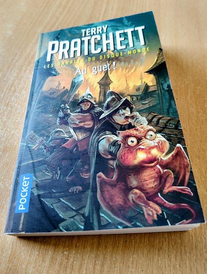 un livre avec le titre
"Terry Pratchett
Les annales du disque-monde
Au guet!