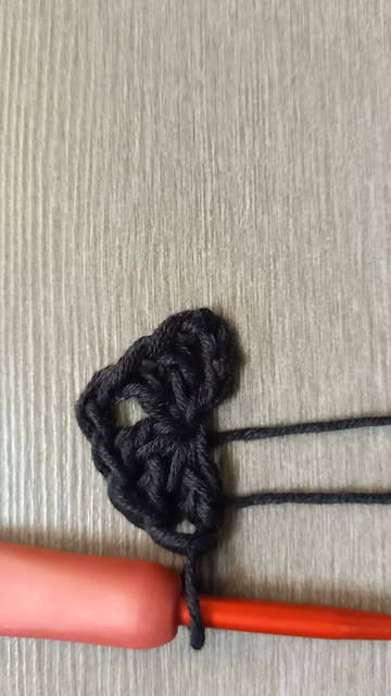Primera vuelta del chal, solo negro.

Es un anillo mágico con dos grupos de 3 puntos separados por dos cadenetas.