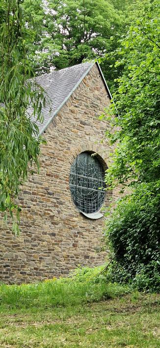 Ein rundes Fenster in einem Kirchengebäude.