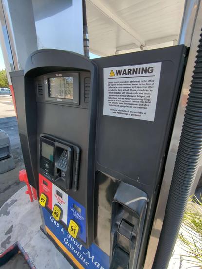 A gas pump with a prop 65 warning sticker
