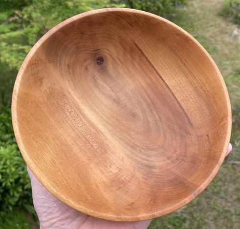 A small wooden bowl held in a hand.