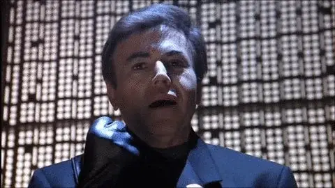 Alfred Bester, a fascist telepath, gripping his hand in a motion to indicate he has the information he was torturing someone for before they died.