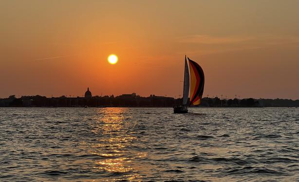 Sailboat and sunset over the US Naval Academy, Annapolis MD.