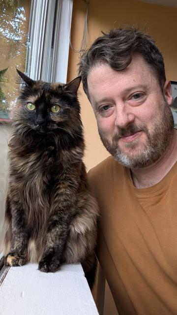Selfie of a bearded guy with a long haired tortoiseshell cat
