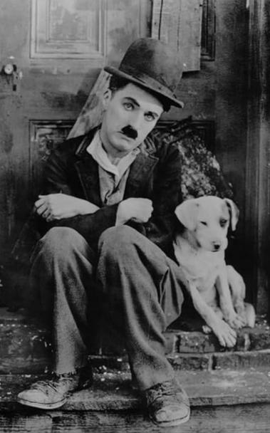 Charlie Chaplin in his hobo character with a cute dog