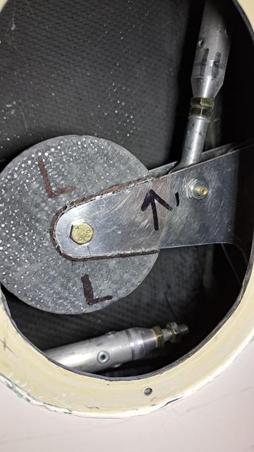 We are looking into the oval access/inspection port in the lower part of the vertical fin. The mass balance looks like a large disk. To its right is a push-pull tube that runs up to the elevator. Below the mass balance is the end of a (very long) push-pull tube that comes from the cockpit and control stick. I have disconnected this part because it is not important in determining the mass...which I determined by trial and error with pieces of scrap steel.

I refuse to melt and cast molten lead. Fortunately, I could make a heavy enough disk of lead shot and epoxy that was small enough to allow proper operation.

The density of lead? Easy...search engine or engineering book.

The density of epoxy? Read the documentation.

The density of a randomly packed bunch of spheres? Learn about sphere packing:
https://en.wikipedia.org/wiki/Sphere_packing

I used 66% as the packing value.

The two 'leaves' of the bell crank are spaced 7/8 inch apart. That constrains my disk thickness. OK, what diameter? Simple spreadsheet math...check the available room...OK, I can do this.

Make a circular mold from scrap wood. (Destroy the mold when demolding...one-shot use, no big deal.)

When molding the lead shot and epoxy...next time, use epoxy with less thickening agent so that its lower viscosity.

The disk ended up a bit thicker than planned...about 1/16th inch (1.5 mm).

What to do? Next picture....
