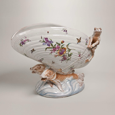 official museum photo of the object, front profile on light grey background “Currently on view, this glazed-earthenware letter holder by Emile Gallé certainly conjures up mysteries of the deep blue sea. Born in 1846 to an enterprising father in the ceramics and glass industry, Gallé grew up surrounded by nature—the city’s flower market was right outside his father’s home and salesroom. The artist’s love of nature, filtered through the lens of his imagination, produced whimsical objects, such as this frog holding the reins of a fish-propelled clamshell. Fancy finding your letters or bills in a container designed by Gallé?” (Description from museum’s page)