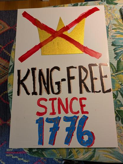 A handmade poster with a crown icon crossed out by a red X. It says "King-free since 1776" in black, gold, red, and blue text.