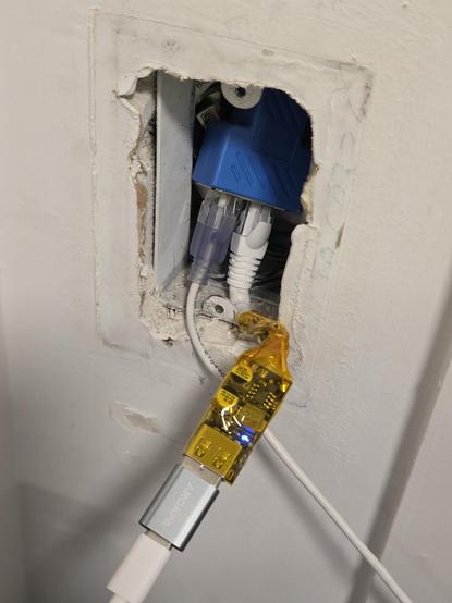 The USB buck converter connected in the wall.