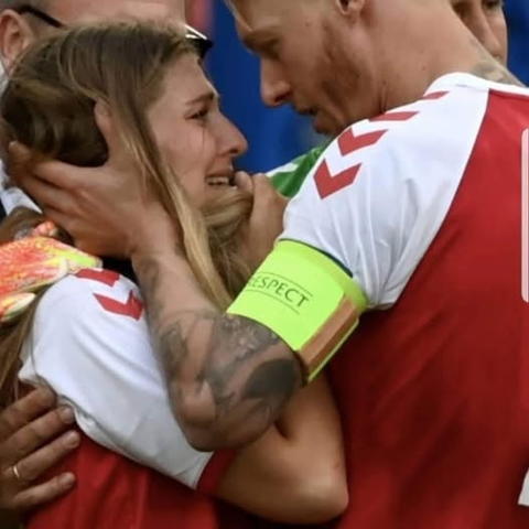 a picture of a footballer ghugging and giving support to a woman in the crowd