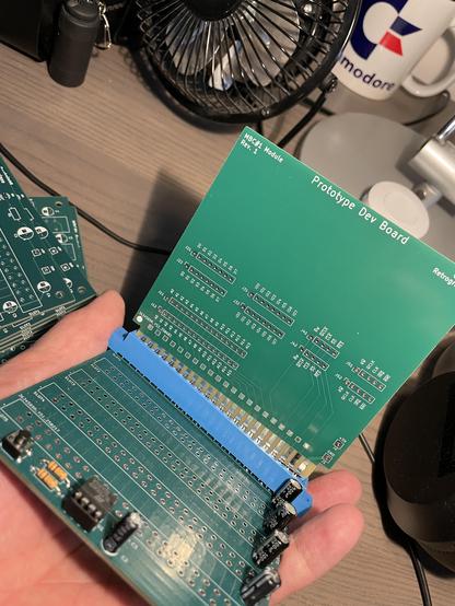 A backplane PCB with a row of five 44 pin sockets, only one of which is populated. Into it, the edge connector of a PCB marked Prototype Dev Board (breaking out all the bus signals) is inserted. Except the right end of it, which doesn't actually fit into the socket.
