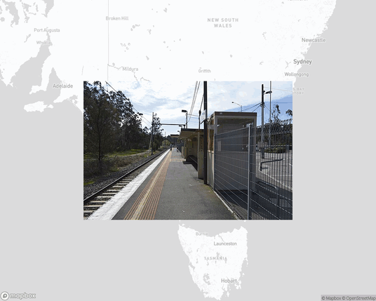 A photo of or from a train station from the linked website, overlaid on a cropped world map where it's located.