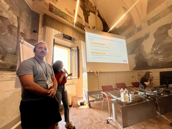 Luiz and Rania from TEam Slytherin are presenting in the Fresco Room at BErtinoro Castle