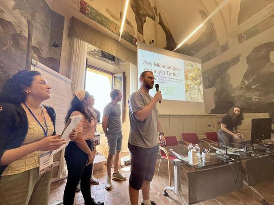 Team Vulcan presenting their research results on Giorgio Vasari's work in the Fresco Room at BErtinoro Castle.
