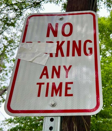 A street sign that reads:

NO
PARKING
ANY TIME 

with the letters "PAR" taped up so that it reads:

NO
**KING
ANY TIME