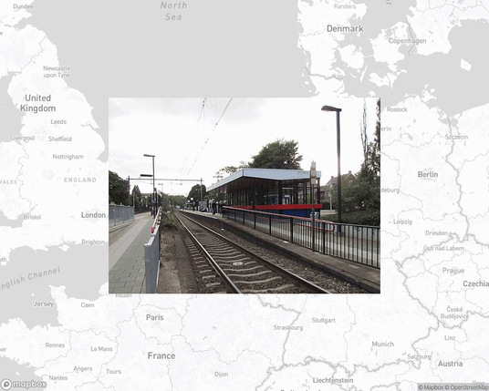 A photo of or from a train station from the linked website, overlaid on a cropped world map where it's located.