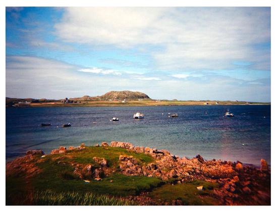 Colour photograph showing a stretch of water between two islands.
