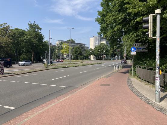 Auf dem Foto ist ein typisch roter Bremer Radweg zu sehen, der an einer Engstelle durch ein Schild zu einem Fußweg umgewidmet wird