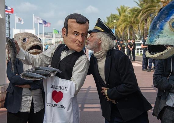Images du collectif "The Océan Rebellion" montrant Emmanuel Macron (président de la France) et le Captain Iglo (les lobbies de la pêche industrielle) faisant un bisou