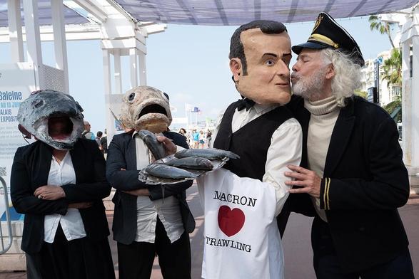 Images du collectif "The Océan Rebellion" montrant Emmanuel Macron (président de la France) et le Captain Iglo (les lobbies de la pêche industrielle) faisant un bisou