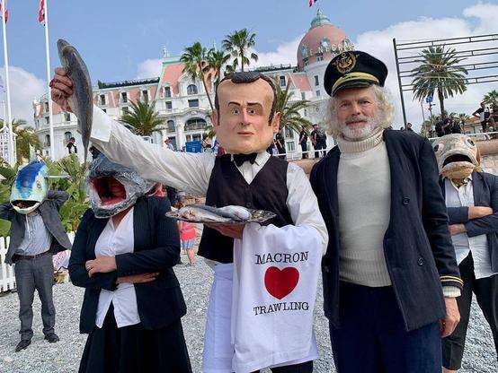 Images du collectif "The Océan Rebellion" montrant Emmanuel Macron (président de la France) et le Captain Iglo (les lobbies de la pêche industrielle) tendant un poisson mort