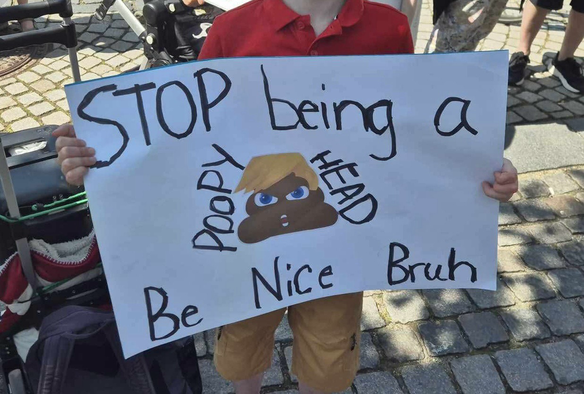 Bagsiden af Sith-skiltet viser en poop emoji med Trump-hår. Teksten lyder: “STOP being a POOPY HEAD. Be Nice Bruh”