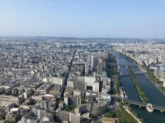 Vue depuis la Tour Eiffel vers l’ouest : à droite, la Seine ; la ville occupe les 3/4 de l’image. En haut, grand ciel bleu