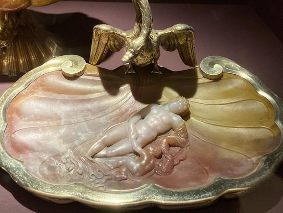 Vue de la coupe de Miseroni : Vénus allongée avec Cupidon à côté. Elle est taillée dans une pierre rose et jaune de forme de coquillage