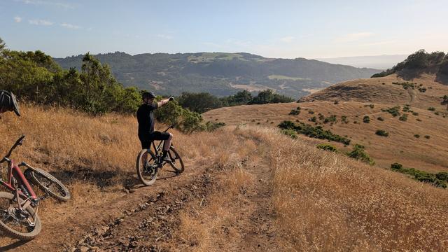 A bike rider points at a hill