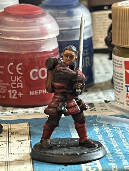 A female warrior with a big sword and red armour.