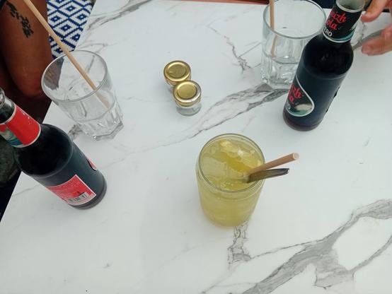 2 breizh cola, 1 citronnade, 2 verres vides, 2 petits pots sur 1 table en marbre vannetais