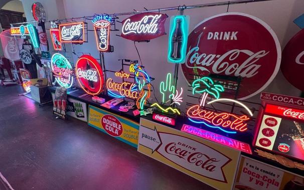 Collection of Coke signs, including several neon ones