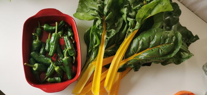 Des cardes jaunes et des poivrons padrons sur une table