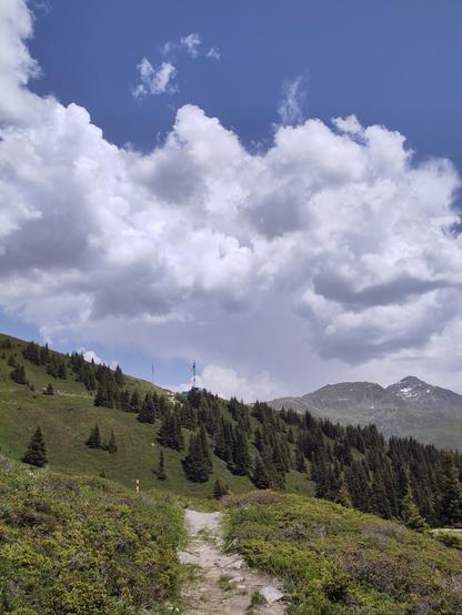 Foto. Berglandschaft, am Horizont zwei Turmdrehkrane.