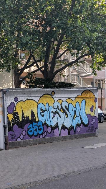 Graffiti saying GIESSEN in bright colours on a small wall