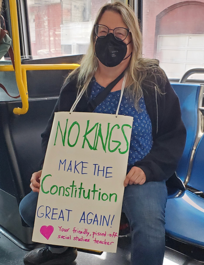 Woman on bus with sign. No Kings make the Constitution Great Again.