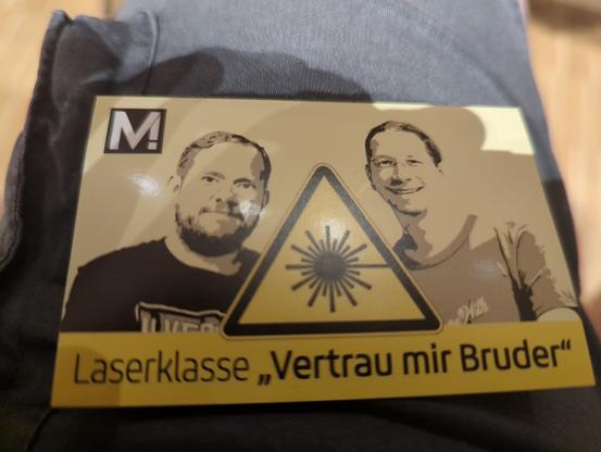 Bild von einem Aufkleber mit dem Laserwarnsymbol und der Aufschrift Laserklasse "Vertraut mir Bruder"