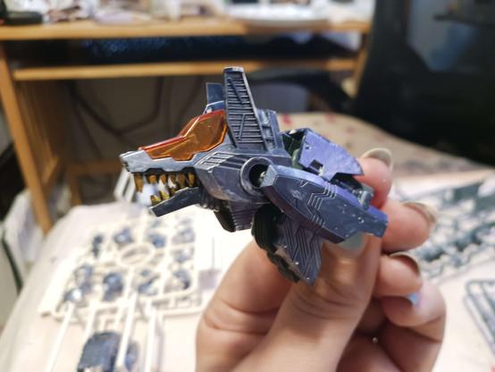 A photograph of the finished head of Good Boy's new body. It's an HMM command wolf, same as the original, but nearly every part is painted here: the teeth are gold, painted by me because this release doesn't have them prepainted, the armour is dark blue, with a metallic sheen, and the skeleton, not really showing in the picture too well, is black and shiny.