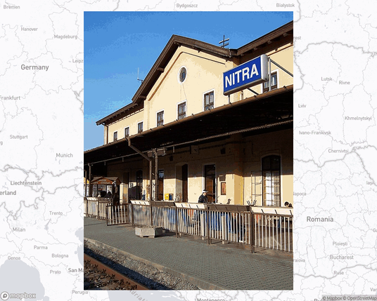 A photo of or from a train station from the linked website, overlaid on a cropped world map where it's located.