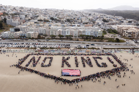 no kings san fran upside down flag and huge group of people on beach