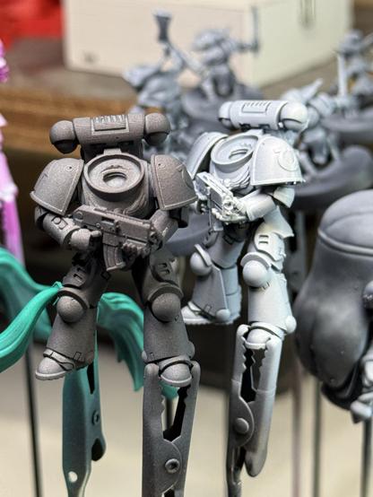 On the left alligator clip is the space marine body in gray, on the right an zenithal white sprayed body.