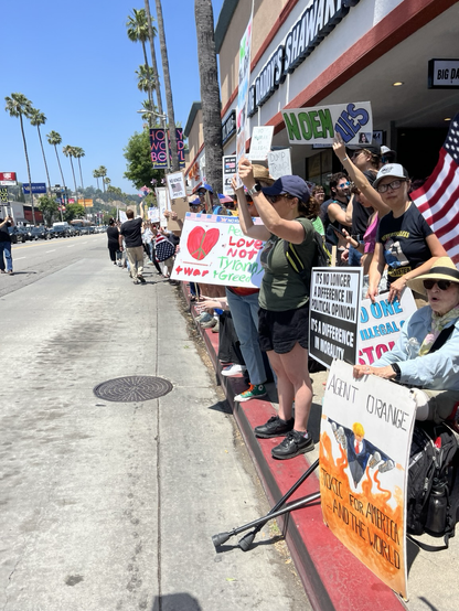 An old lady in a wheelchair is one of thousands of protesters who filled the sidewalks of this busy intersection in the san fernando valley