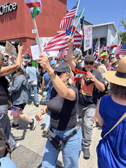 Demonstrators wave American flags and carry posters advocating freedom and opposing dictatorship