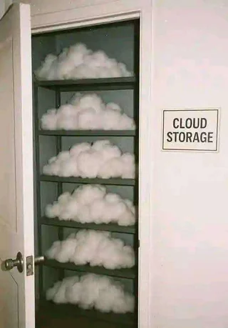 A humorous image showing a closet with shelves filled with fluffy white cotton resembling clouds. A sign on the wall next to the open door reads “CLOUD STORAGE,” playing on the double meaning of digital cloud storage and literal clouds stored on shelves.