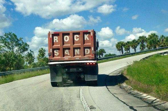 The rear of a truck designed to carry minerals. It's marked "ROCK-SAND"