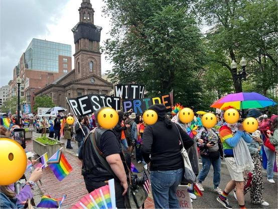 Boston Pride procession near the Public Garden. People are displaying rainbow flags, fans, umbrellas, you name it. A big three piece banner in the procession says “RESIST WITH PRIDE”