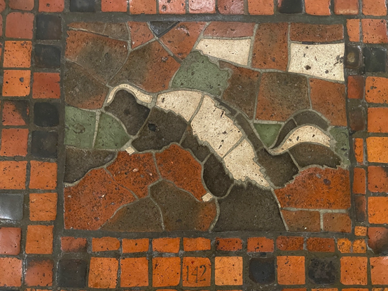 photo of of one of two skunk mosaic tiles on the PA Capitol rotunda floor from 1906, numbered 142 - the more worn of the two (in an area with more foot traffic)