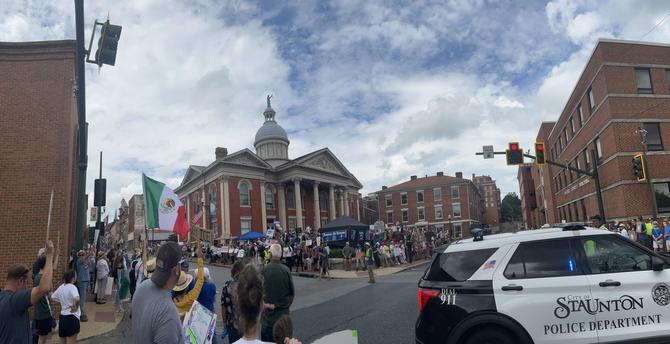 Staunton District courthouse with peaceful No Kings protesters outside. Cops car in foreground.